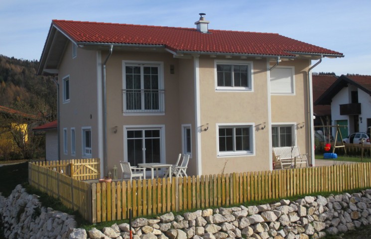 Einfamilienhaus mit Natursteinmauer und Holzzaun