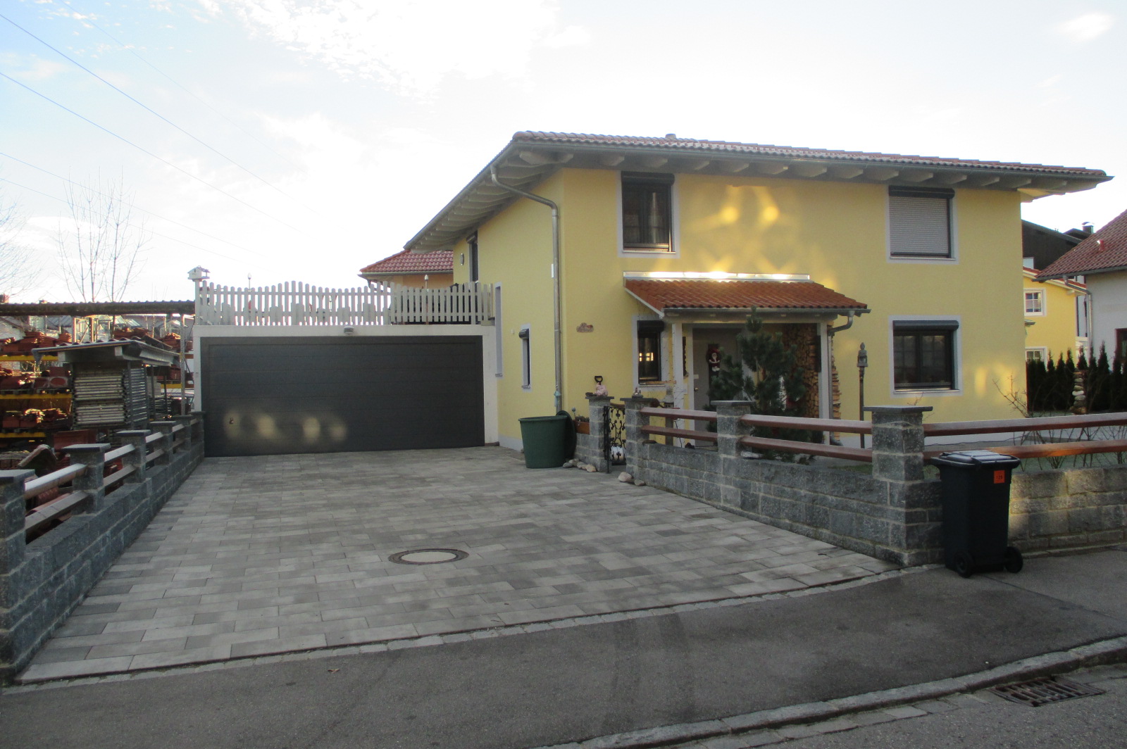 Einfamilienhaus mit Walmdach, Garage mit Sektionaltor und darüberliegender Dachterrasse 