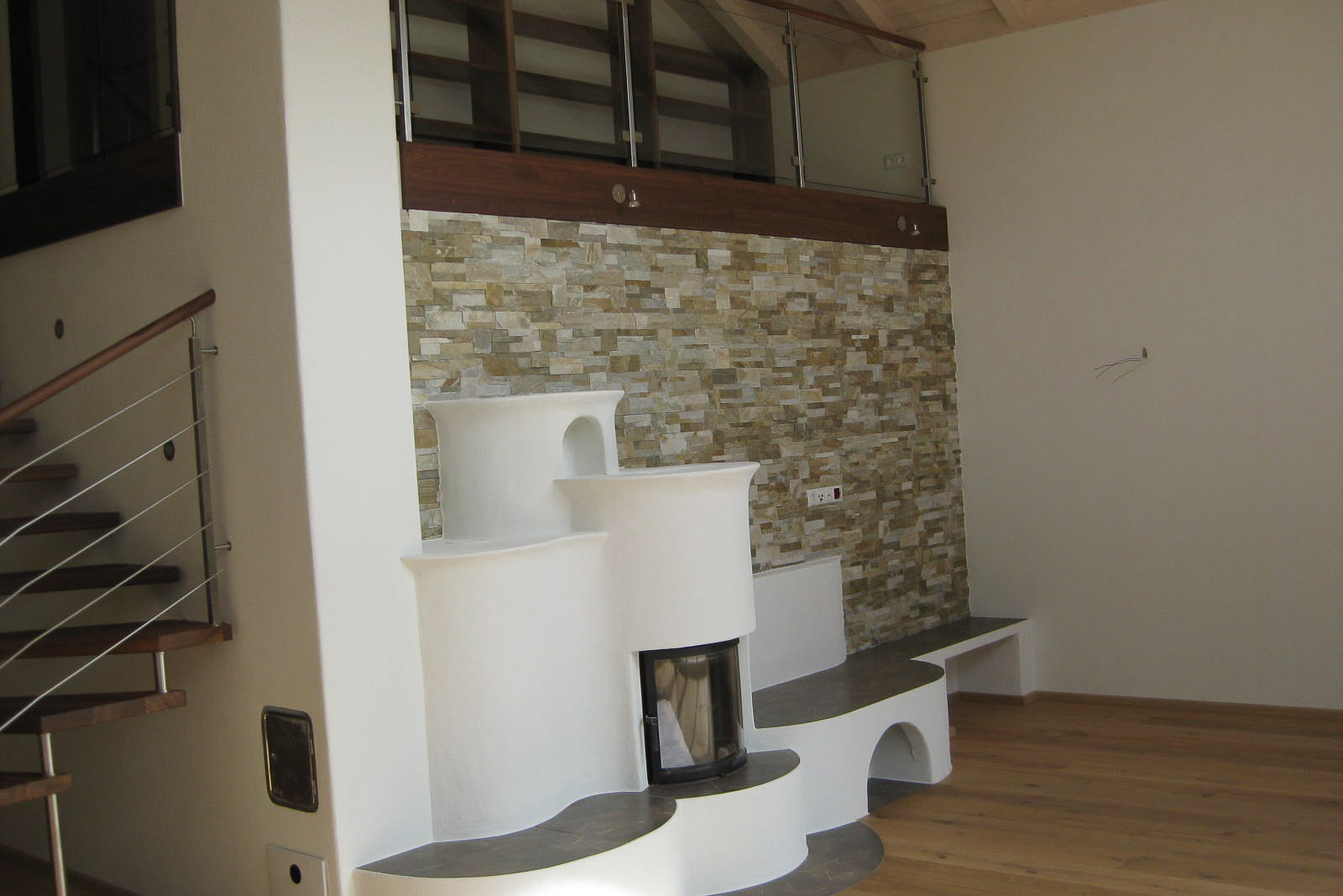 Wohnbereich mit Holzofen und Natursteinwand