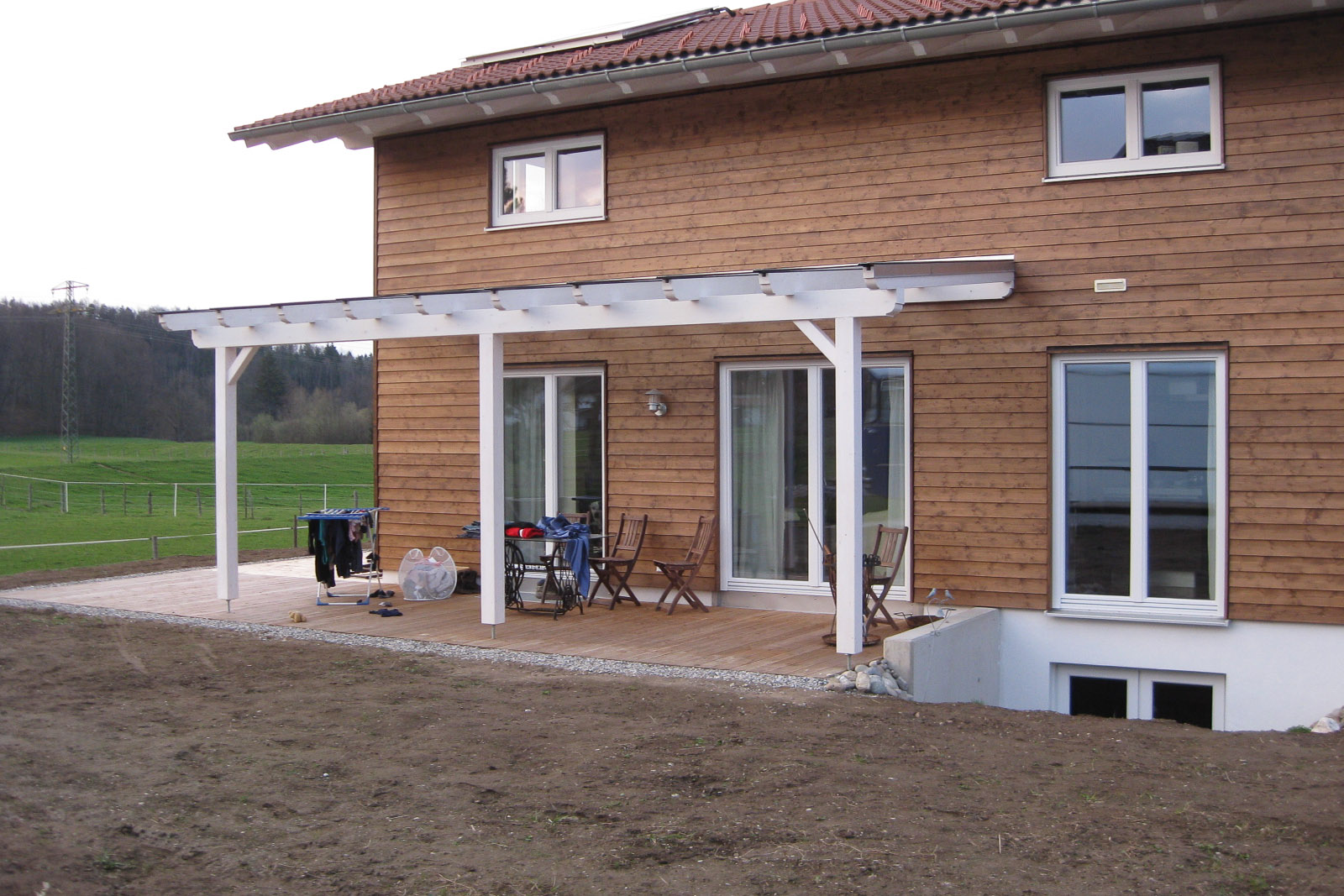 Einfamilienhaus mit Holzfassade - Lichtgraben und Terrassenüberdachung